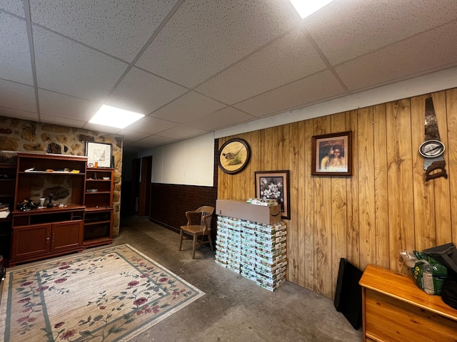 1416 13th Ave, Clarkfield, MN 56223 - sitting room featuring a paneled ceiling, wooden walls, and concrete floors