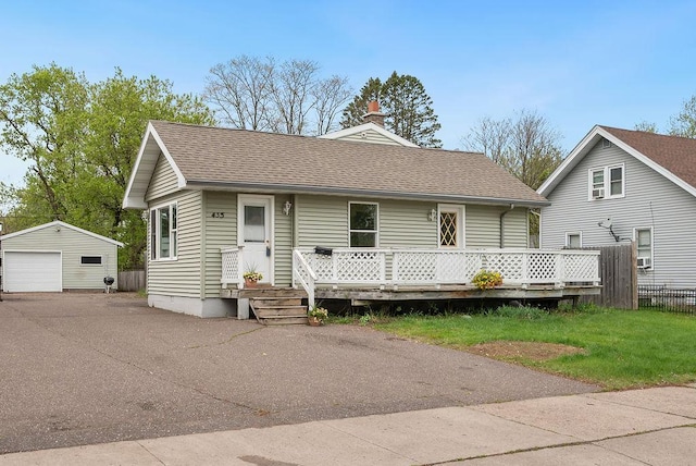 435 6th St, Cloquet, MN 55720 - view of front of house featuring a garage, an outdoor structure, a shingled roof, fence, and driveway