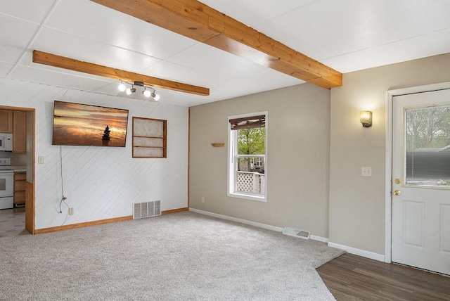 435 6th St, Cloquet, MN 55720 - unfurnished living room featuring baseboards, beam ceiling, wood walls, and carpet flooring