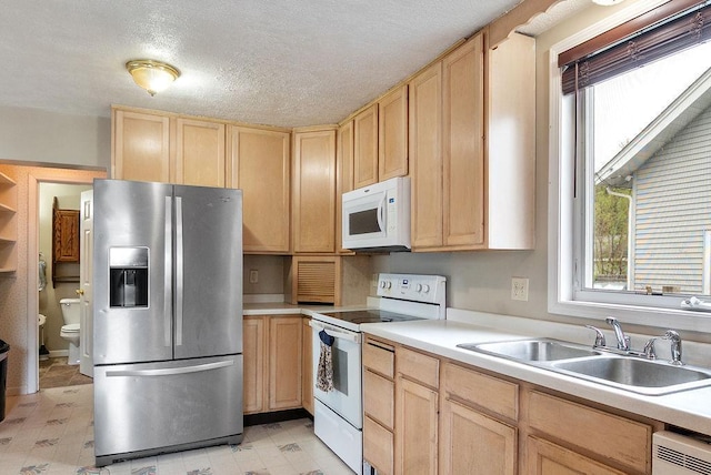 435 6th St, Cloquet, MN 55720 - kitchen with white appliances, light brown cabinetry, a sink, plenty of natural light, and a textured ceiling