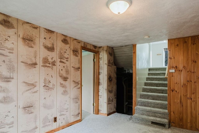 435 6th St, Cloquet, MN 55720 - empty room featuring wood walls, carpet, stairs, and a textured ceiling