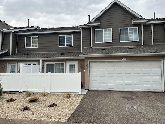 7122 Excelsior Way, Saint Louis Park, MN 55426 - townhome / multi-family property with fence, asphalt driveway, roof with shingles, and a garage