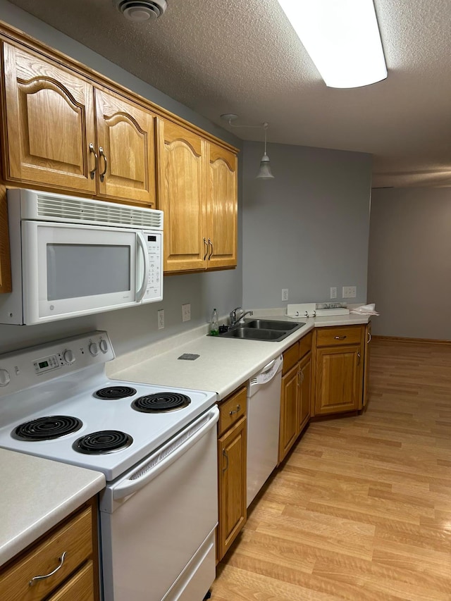 7122 Excelsior Way, Saint Louis Park, MN 55426 - kitchen with white appliances, a sink, light wood-type flooring, a textured ceiling, and light countertops