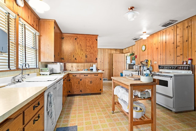 21895 County Road 8, Bovey, MN 55709 - kitchen featuring white appliances, light floors, wood walls, light countertops, and brown cabinets