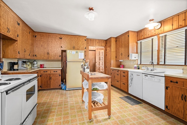 21895 County Road 8, Bovey, MN 55709 - kitchen with white appliances, light flooring, brown cabinets, light countertops, and wood walls