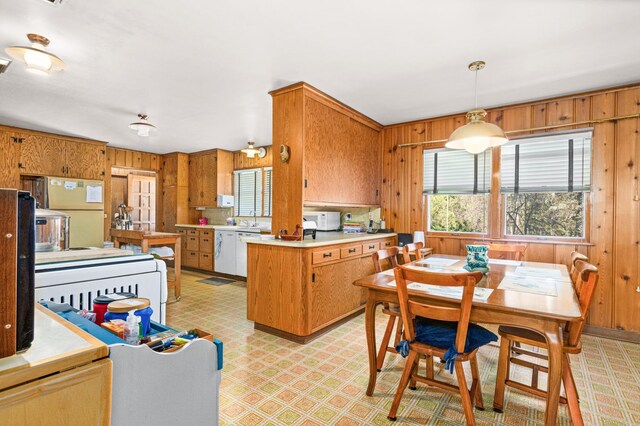 21895 County Road 8, Bovey, MN 55709 - kitchen with wooden walls, a peninsula, light countertops, light floors, and white appliances