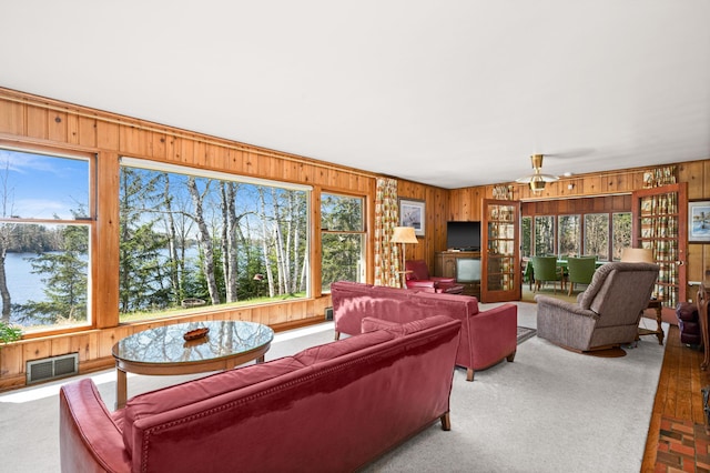 21895 County Road 8, Bovey, MN 55709 - carpeted living area featuring wooden walls and a ceiling fan
