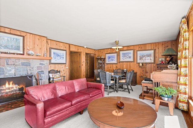 21895 County Road 8, Bovey, MN 55709 - living room featuring wooden walls, a fireplace, and carpet flooring