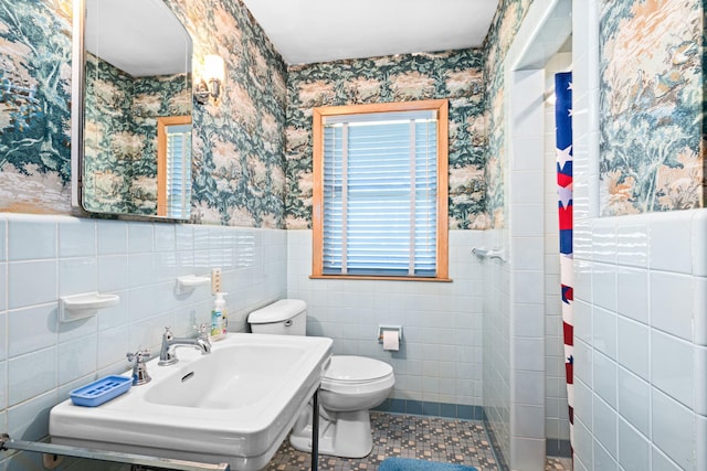21895 County Road 8, Bovey, MN 55709 - bathroom featuring wallpapered walls, toilet, wainscoting, tile walls, and a shower with shower curtain