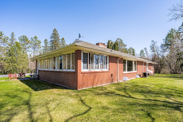 21895 County Road 8, Bovey, MN 55709 - view of side of property with brick siding, a chimney, a yard, and central AC