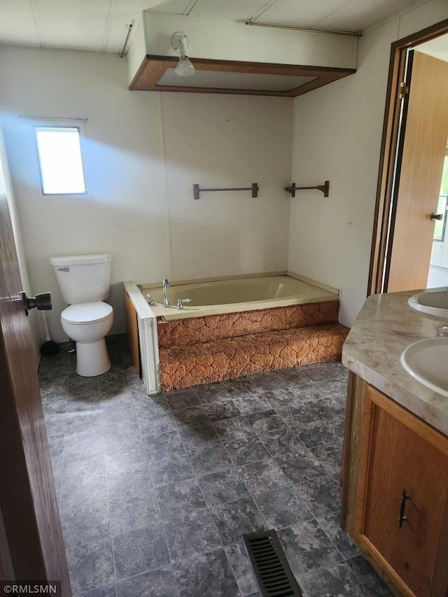full bath featuring toilet, a bath, and vanity