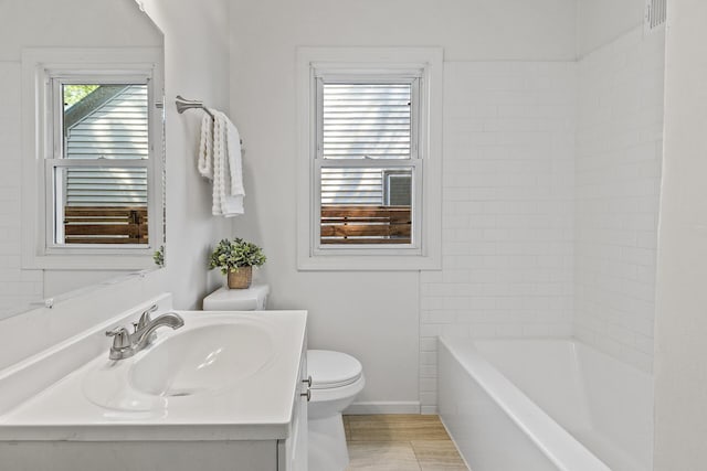 bathroom with toilet, vanity, and baseboards