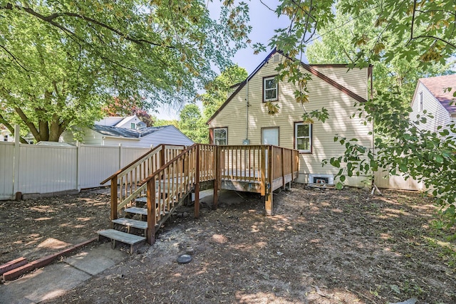 rear view of house featuring a deck, fence, and stairway
