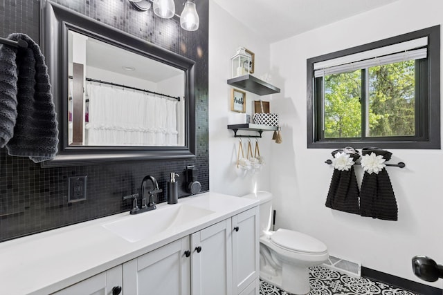 6242 Pecan St, North Branch, MN 55056 - bathroom with backsplash, tile patterned floors, vanity, and toilet