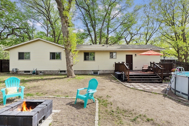 6242 Pecan St, North Branch, MN 55056 - rear view of house with a fire pit, a deck, fence, and central AC unit