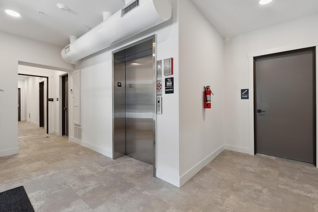 corridor with elevator and baseboards