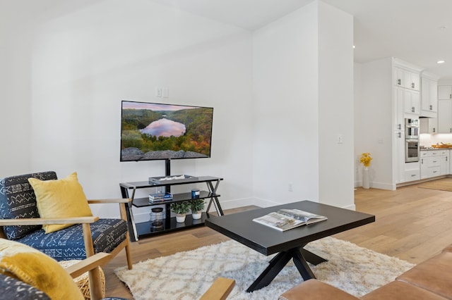 living area with light wood-style flooring, baseboards, and recessed lighting