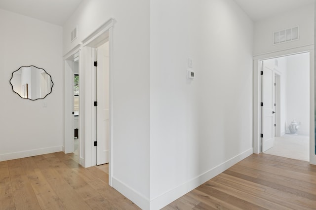 hallway with light wood finished floors and baseboards