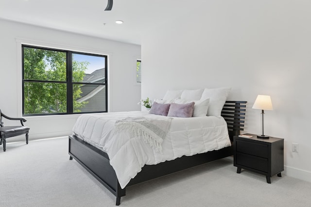 bedroom featuring light colored carpet and baseboards