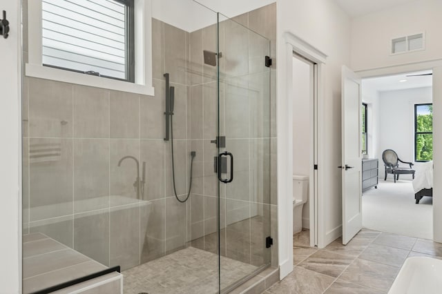 full bathroom with a stall shower, toilet, connected bathroom, and baseboards