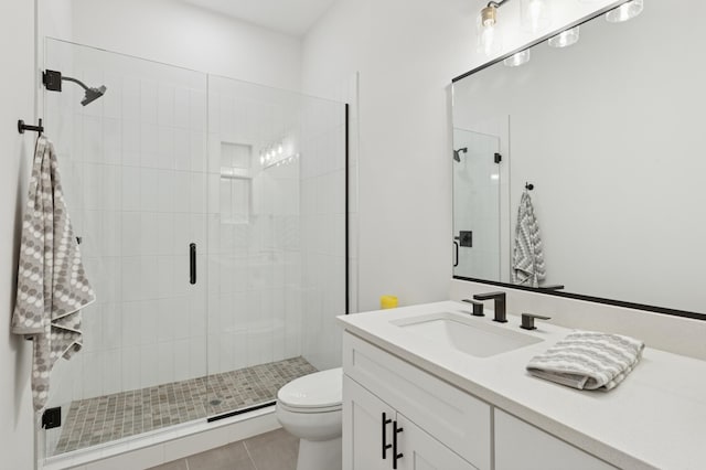 full bath featuring toilet, a shower stall, vanity, and tile patterned flooring