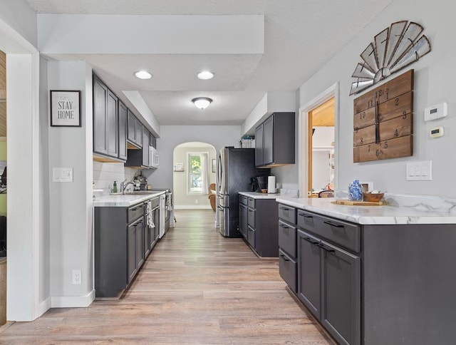 212 4, Montevideo, MN 56265 - kitchen featuring arched walkways, light wood finished floors, light countertops, baseboards, and recessed lighting