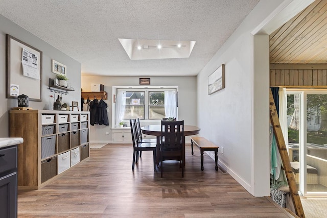 212 4, Montevideo, MN 56265 - dining room with a skylight, wood finished floors, a textured ceiling, and baseboards