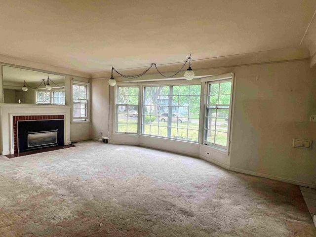 unfurnished living room with a brick fireplace, baseboards, and carpet