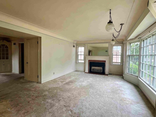 unfurnished living room with carpet flooring, a fireplace with flush hearth, and baseboards