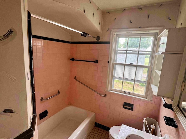 bathroom with toilet, tile walls, tile patterned flooring, and shower / bath combination