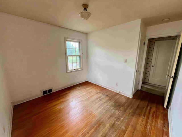 unfurnished bedroom featuring wood finished floors and baseboards