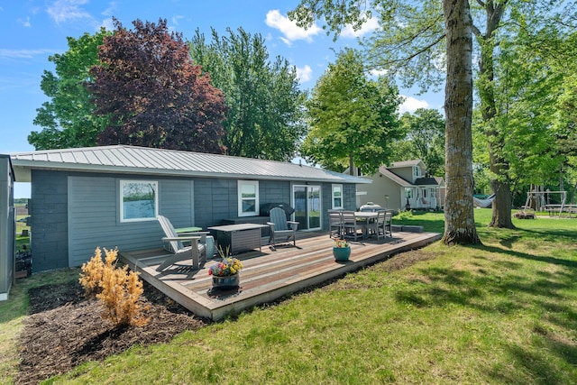 46710 Glens Beach Rd, Elysian Twp, MN 56096 - back of house with a lawn, a wooden deck, metal roof, and outdoor dining space