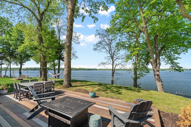 46710 Glens Beach Rd, Elysian Twp, MN 56096 - wooden deck featuring a water view, outdoor dining area, and a yard