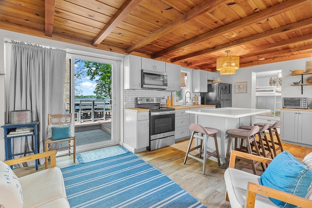 46710 Glens Beach Rd, Elysian Twp, MN 56096 - kitchen featuring stainless steel appliances, wood ceiling with exposed beams, light countertops, light wood finished floors, and a sink