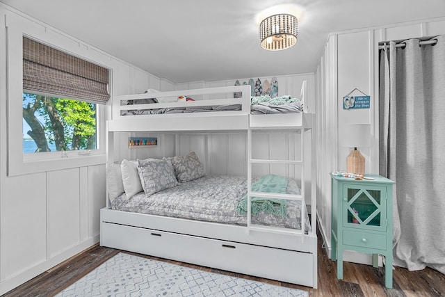 46710 Glens Beach Rd, Elysian Twp, MN 56096 - bedroom featuring wood finished floors, a chandelier, and a decorative wall