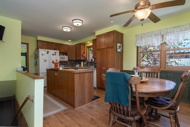 207 2nd Ave W, Balsam Lake, WI 54810 - kitchen featuring white appliances, light wood finished floors, a kitchen island, decorative backsplash, and a ceiling fan