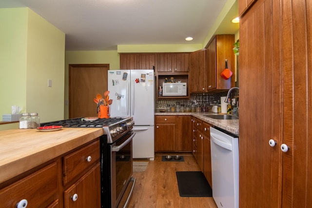 207 2nd Ave W, Balsam Lake, WI 54810 - kitchen featuring a sink, white appliances, butcher block countertops, brown cabinetry, and light wood finished floors