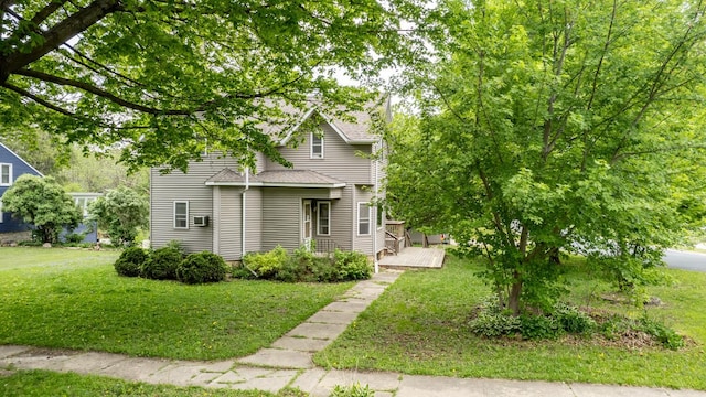 view of front of house with a front lawn, a wooden deck, and roof with shingles