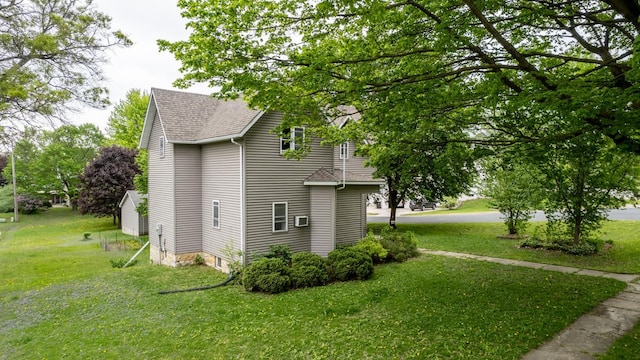 view of side of home with roof with shingles and a yard