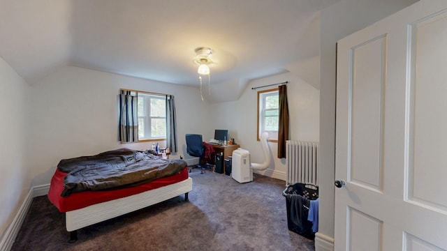 carpeted bedroom featuring radiator heating unit, multiple windows, lofted ceiling, baseboards, and an office area