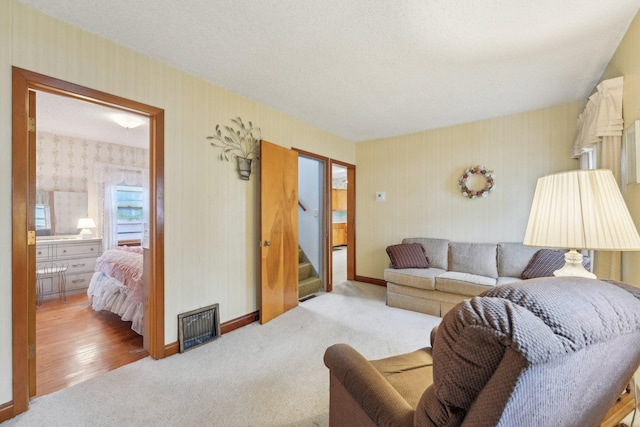 4518 Colfax Ave N, Minneapolis, MN 55412 - living area with wallpapered walls, stairs, carpet floors, baseboards, and a textured ceiling