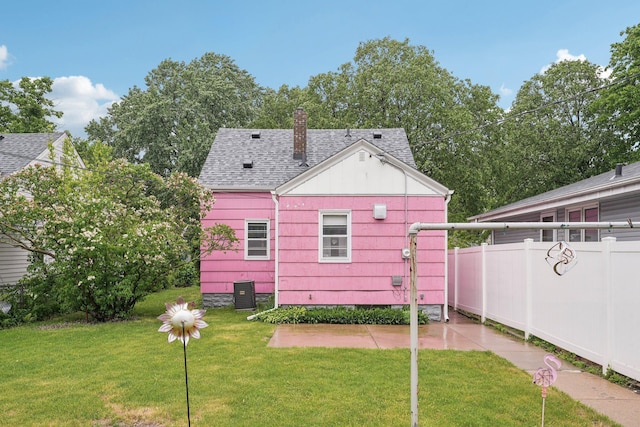 4518 Colfax Ave N, Minneapolis, MN 55412 - rear view of house featuring a shingled roof, a chimney, central AC, and a patio