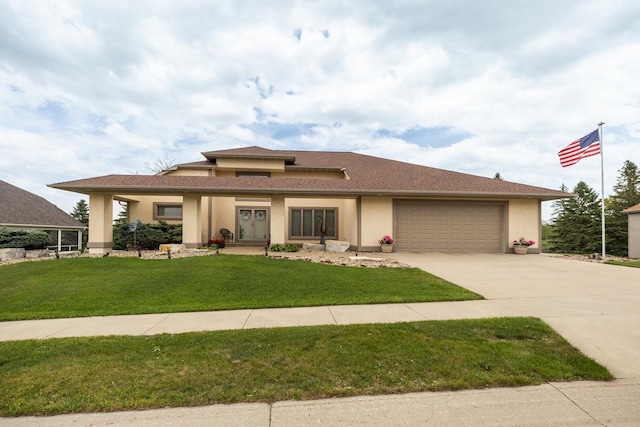 prairie-style home with a garage, concrete driveway, a front yard, and stucco siding
