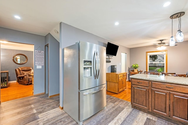 114 3rd Ave E, Truman, MN 56088 - kitchen featuring stainless steel refrigerator with ice dispenser, light wood-style flooring, hanging light fixtures, brown cabinetry, and a ceiling fan
