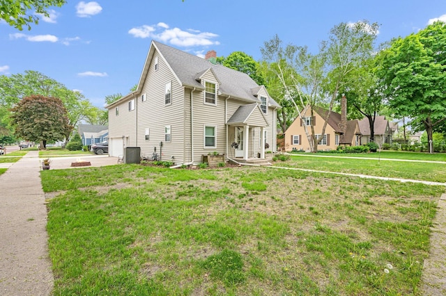 114 3rd Ave E, Truman, MN 56088 - view of front of property featuring central AC, a garage, a front yard, driveway, and a chimney