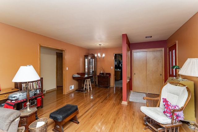 724 16th St NE, Rochester, MN 55906 - living room featuring a chandelier, wood finished floors, and baseboards