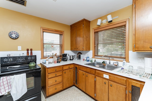 724 16th St NE, Rochester, MN 55906 - kitchen with black range with electric stovetop, a sink, light countertops, and plenty of natural light