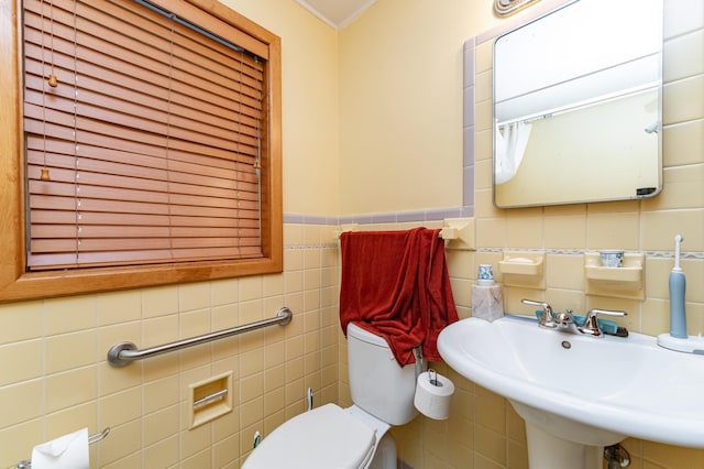 724 16th St NE, Rochester, MN 55906 - bathroom featuring tile walls, toilet, a sink, and a wainscoted wall