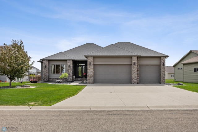 405 12th St NE, Dilworth, MN 56529 - view of front of property featuring an attached garage, a front lawn, concrete driveway, roof with shingles, and stone siding