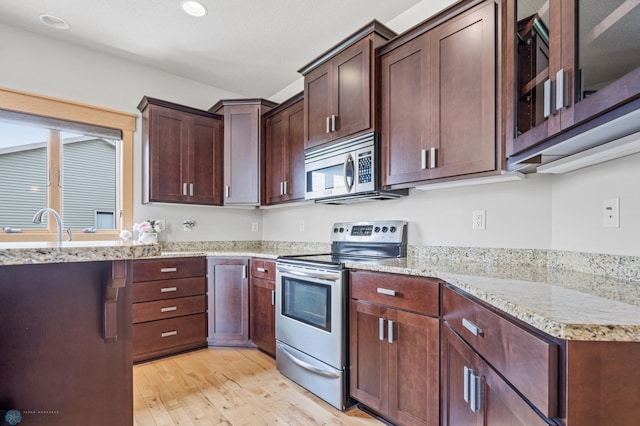 405 12th St NE, Dilworth, MN 56529 - kitchen with stainless steel appliances, light wood-style floors, light stone counters, and recessed lighting